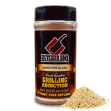 A bottle of Butcher BBQ Grilling Addiction seasoning with a small pile of the seasoning blend spilled in front, set against a plain white background.