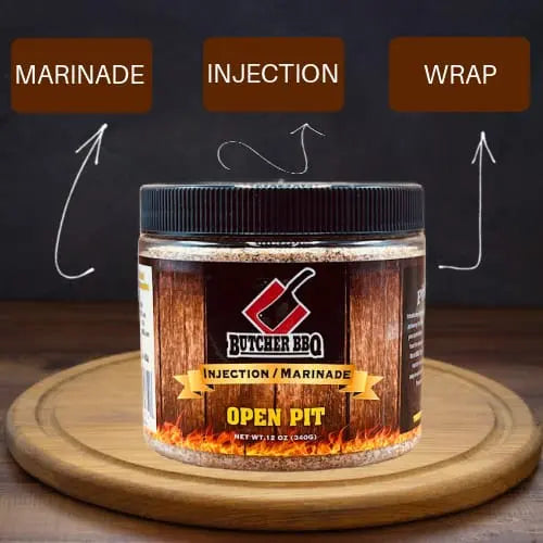 Butcher BBQ Open Pit marinade jar on a wooden board with text labels 'Marinade', 'Injection', and 'Wrap'.