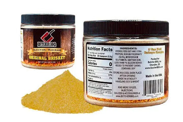 Two jars of Butcher BBQ Original Brisket seasoning with a small pile of seasoning on a white background.