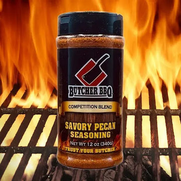 Butcher BBQ Savory Pecan Seasoning bottle on a grill with flames in the background