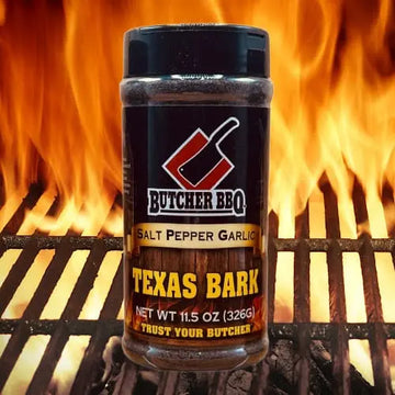 Butcher BBQ Texas Bark seasoning jar on a grill with flames in the background
