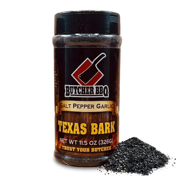 A bottle of Butcher BBQ Salt Pepper Garlic seasoning with a pile of dark Texas Bark seasoning in front, on a white background.