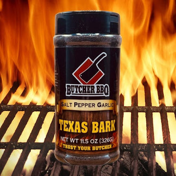 Butcher BBQ Texas Bark seasoning jar on a grill with flames in the background